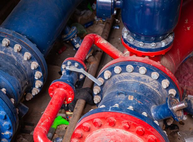 Bildnachweis: Sergii Zhmurchak_Stock-Fotografie-ID:1476792720_Neues unterirdisches Sanitärsystem aus Stahlrohren und Ventilen, rot und blau lackiert. – Stockfoto