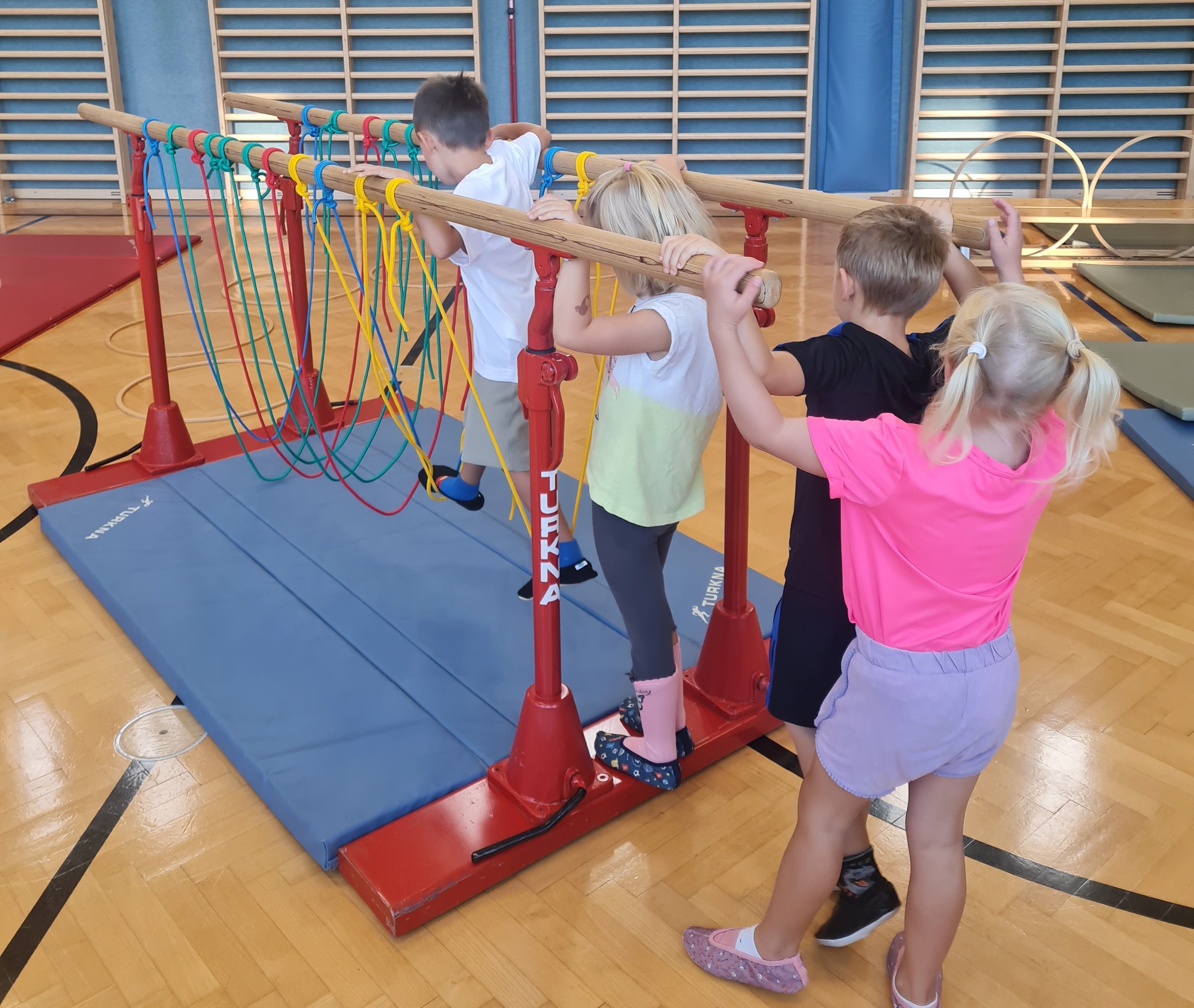 Die Kinder können den Turnsaal von der VS Treffling mitbenutzen, auf dem Bild turnen 4 Kinder im Turnsaal.